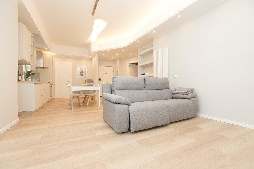 Immagine di un soggiorno minimal di medie dimensioni e aperto con pareti grigie, pavimento in laminato e pavimento marrone