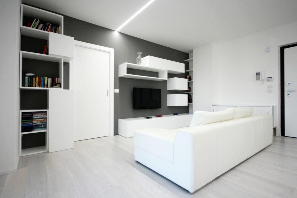 Immagine di un soggiorno moderno aperto con angolo bar, pareti grigie, parquet chiaro, TV a parete e pavimento bianco