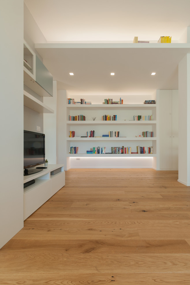 Foto di un soggiorno design di medie dimensioni e aperto con libreria, pareti grigie, parquet chiaro, parete attrezzata e pavimento beige