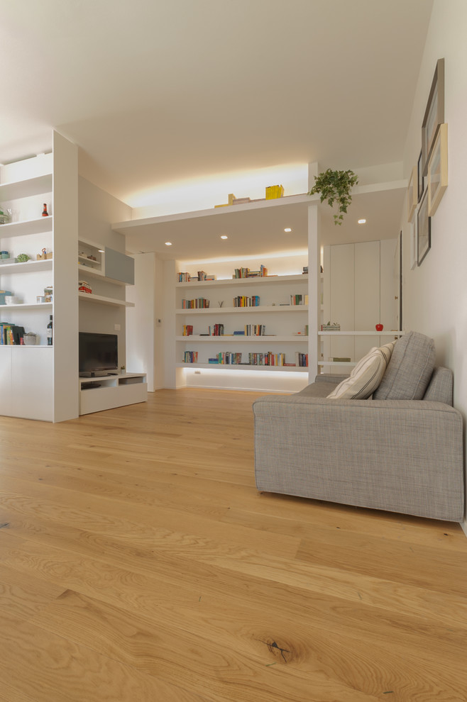 Foto di un soggiorno minimal di medie dimensioni e aperto con libreria, pareti grigie, parquet chiaro, parete attrezzata e pavimento beige