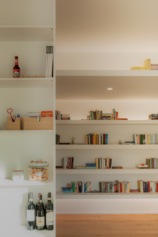 Ispirazione per un soggiorno contemporaneo di medie dimensioni e aperto con libreria, pareti bianche, parquet chiaro, parete attrezzata e pavimento beige
