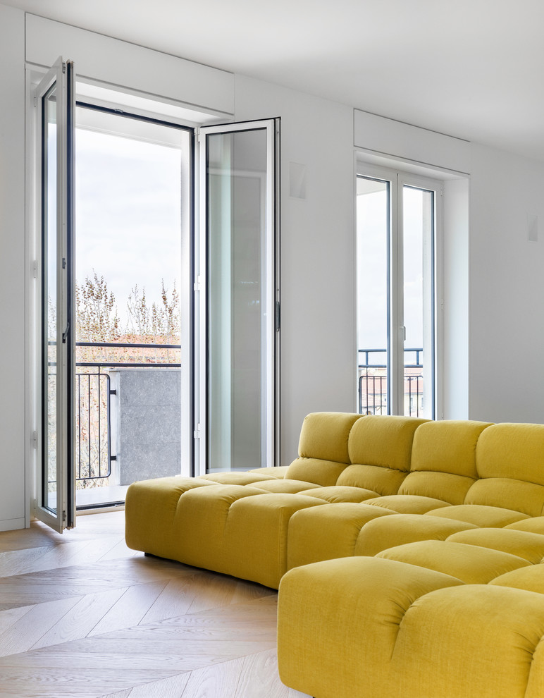 Cette photo montre une salle de séjour moderne de taille moyenne et ouverte avec une bibliothèque ou un coin lecture, un mur blanc, un sol en bois brun, un téléviseur indépendant et un sol beige.