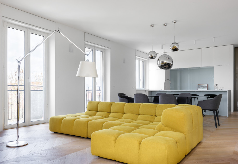 Immagine di un soggiorno minimalista di medie dimensioni e aperto con libreria, pareti bianche, pavimento in legno massello medio, TV autoportante e pavimento beige