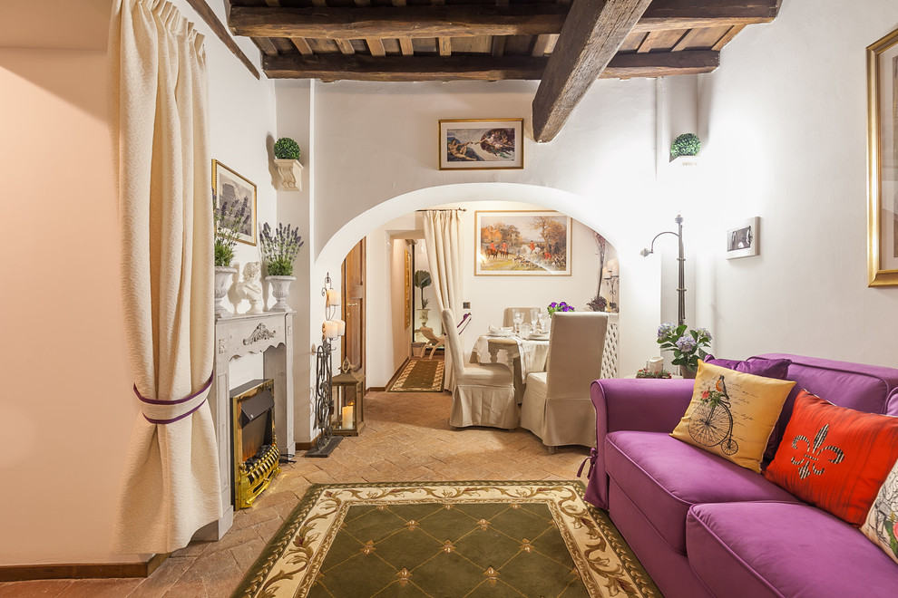 На фото: открытая гостиная комната среднего размера в средиземноморском стиле с белыми стенами, кирпичным полом, печью-буржуйкой и фасадом камина из дерева с