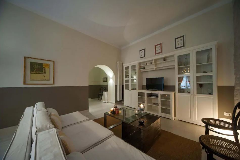 Esempio di un soggiorno chic di medie dimensioni e chiuso con sala formale, pareti multicolore, pavimento in gres porcellanato, parete attrezzata e pavimento beige