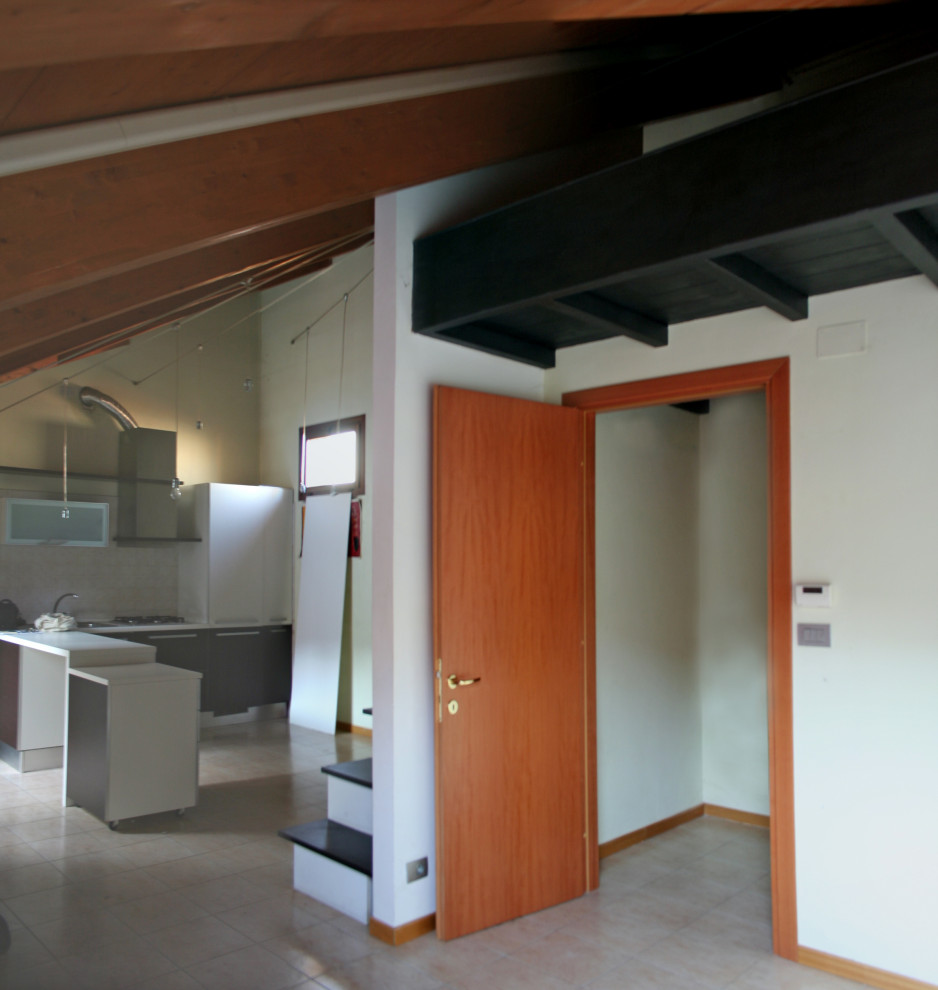 Kleines Eklektisches Wohnzimmer im Loft-Stil mit weißer Wandfarbe, Keramikboden, TV-Wand, rosa Boden und freigelegten Dachbalken in Turin