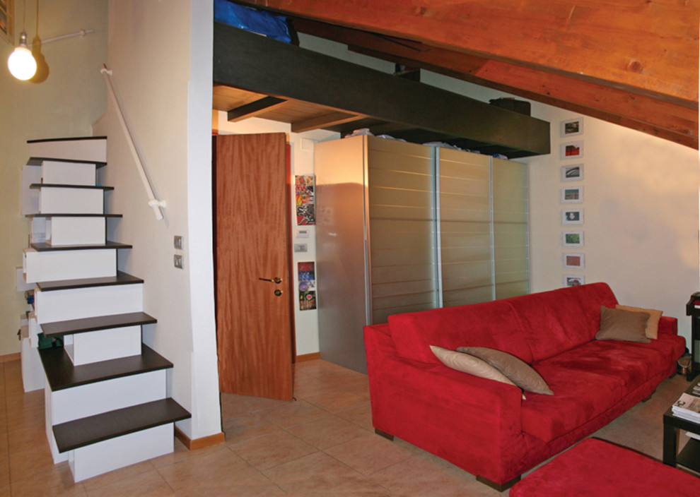 Kleines Eklektisches Wohnzimmer im Loft-Stil mit weißer Wandfarbe, Keramikboden, TV-Wand, rosa Boden und freigelegten Dachbalken in Turin