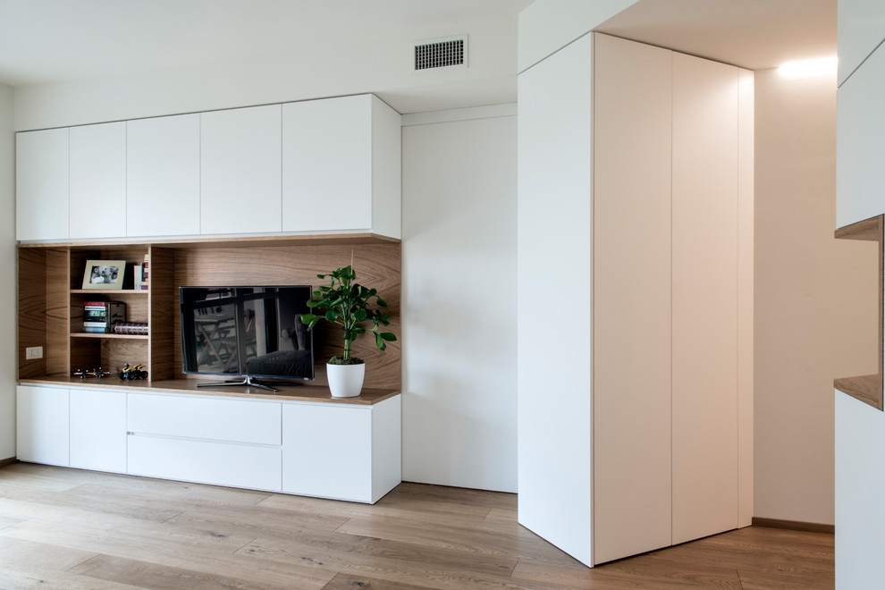 Ispirazione per un soggiorno minimalista di medie dimensioni e aperto con pareti bianche, parquet chiaro e TV a parete