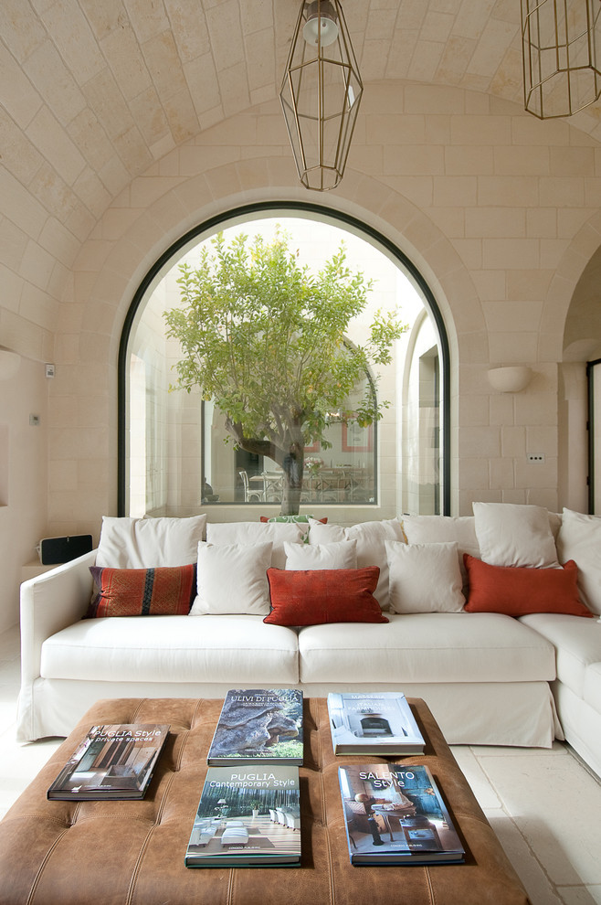 Inspiration for a mid-sized cottage limestone floor and beige floor living room remodel in Other with beige walls, a standard fireplace and a stone fireplace