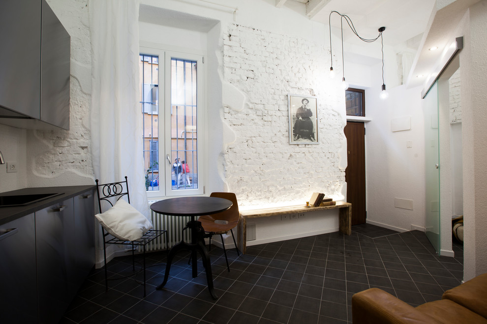 Foto di un piccolo soggiorno industriale aperto con pareti bianche, pavimento in gres porcellanato e pavimento nero
