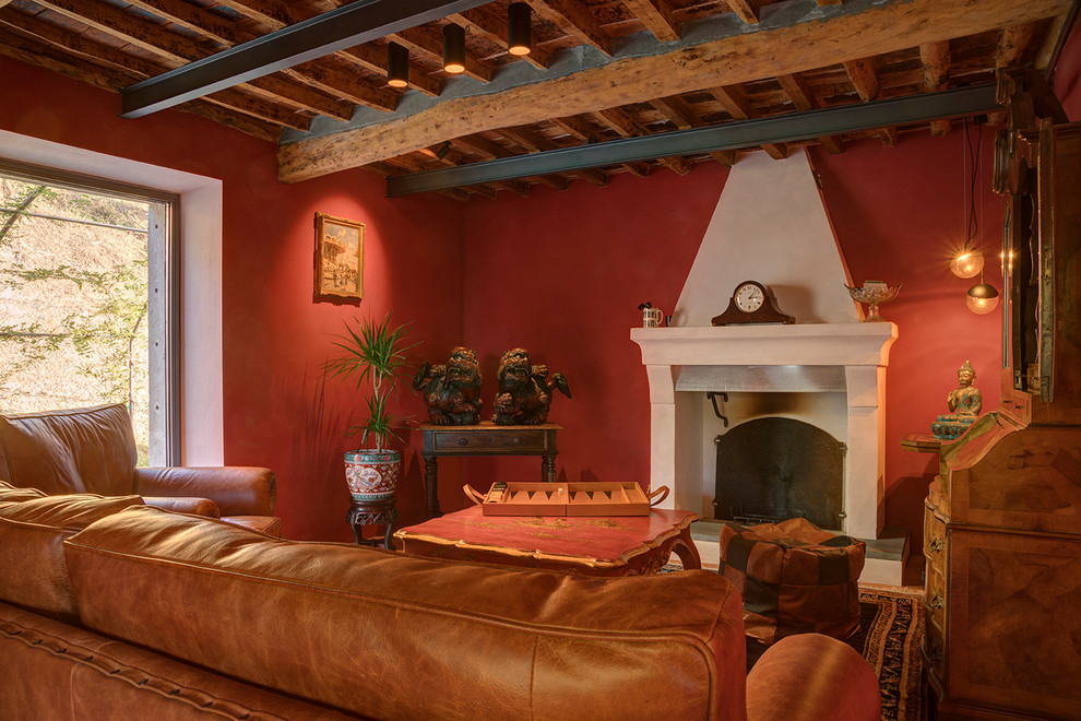Cette photo montre un salon méditerranéen avec une salle de réception, un mur rouge, une cheminée standard et poutres apparentes.