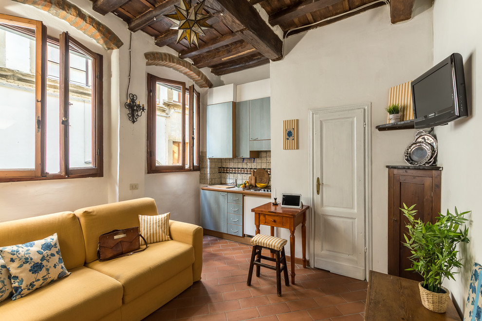 Источник вдохновения для домашнего уюта: маленькая гостиная комната в средиземноморском стиле с полом из терракотовой плитки и красным полом для на участке и в саду