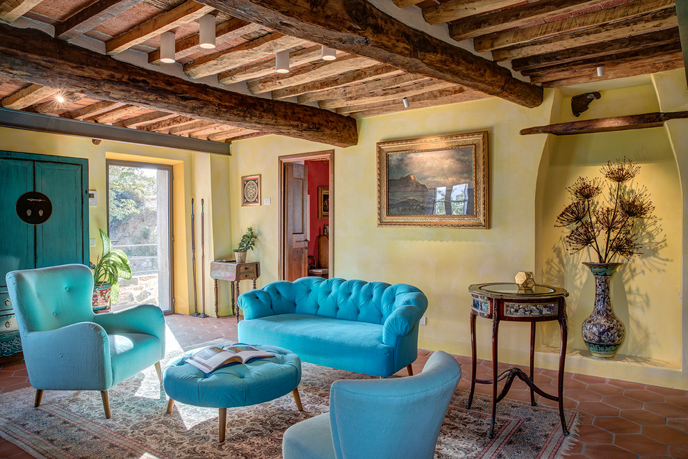 Ispirazione per un soggiorno mediterraneo con sala formale, pareti gialle, pavimento in terracotta, pavimento arancione e travi a vista