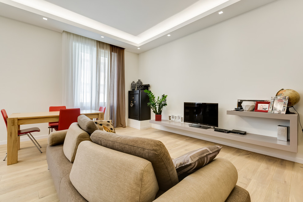Esempio di un soggiorno minimalista di medie dimensioni e aperto con sala formale, pareti bianche, parquet chiaro, TV autoportante e pavimento beige