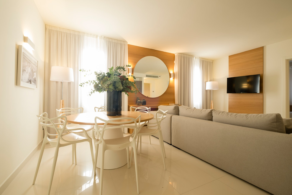Immagine di un piccolo soggiorno minimal aperto con pareti bianche, pavimento in gres porcellanato, TV a parete e pavimento bianco