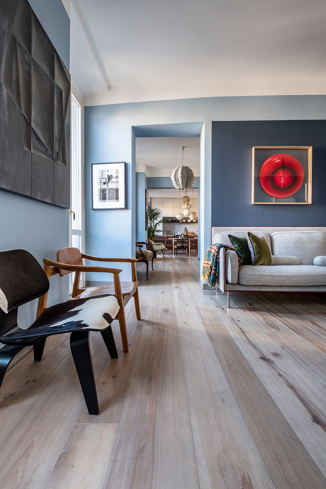 Exempel på ett litet minimalistiskt loftrum, med blå väggar, ljust trägolv, ett bibliotek, en fristående TV och beiget golv