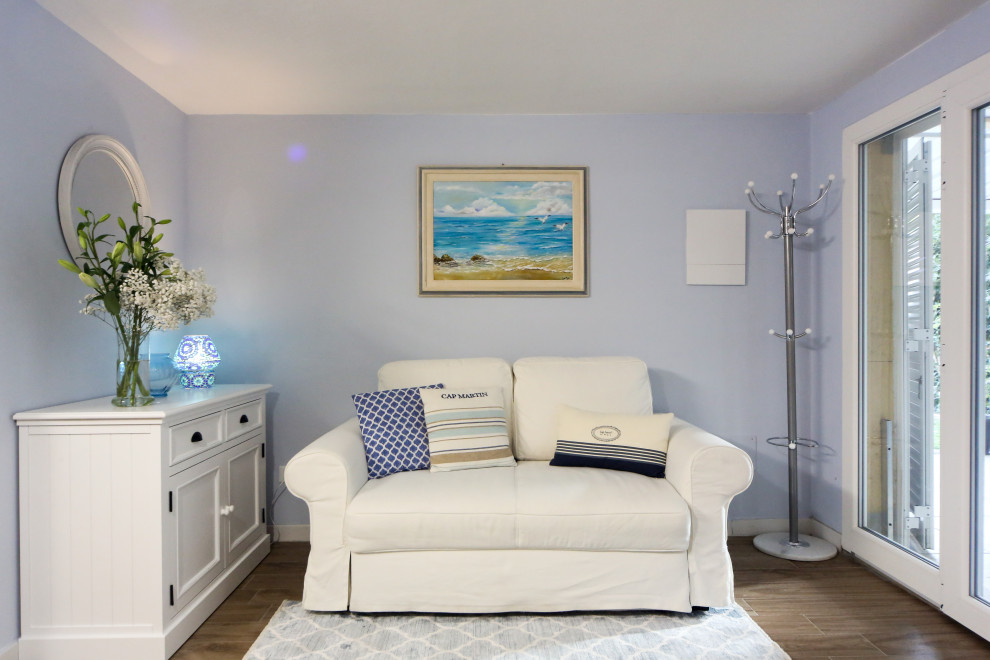 Immagine di un piccolo soggiorno stile marino aperto con pareti blu e pavimento in gres porcellanato