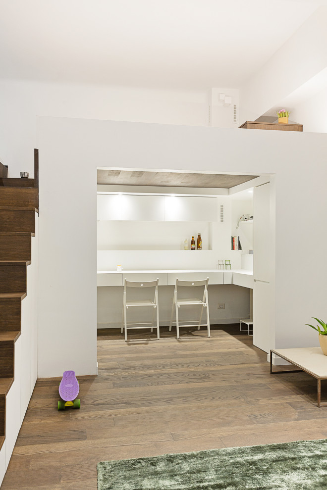 Пример оригинального дизайна: маленькая двухуровневая гостиная комната в стиле модернизм с белыми стенами, темным паркетным полом и коричневым полом для на участке и в саду