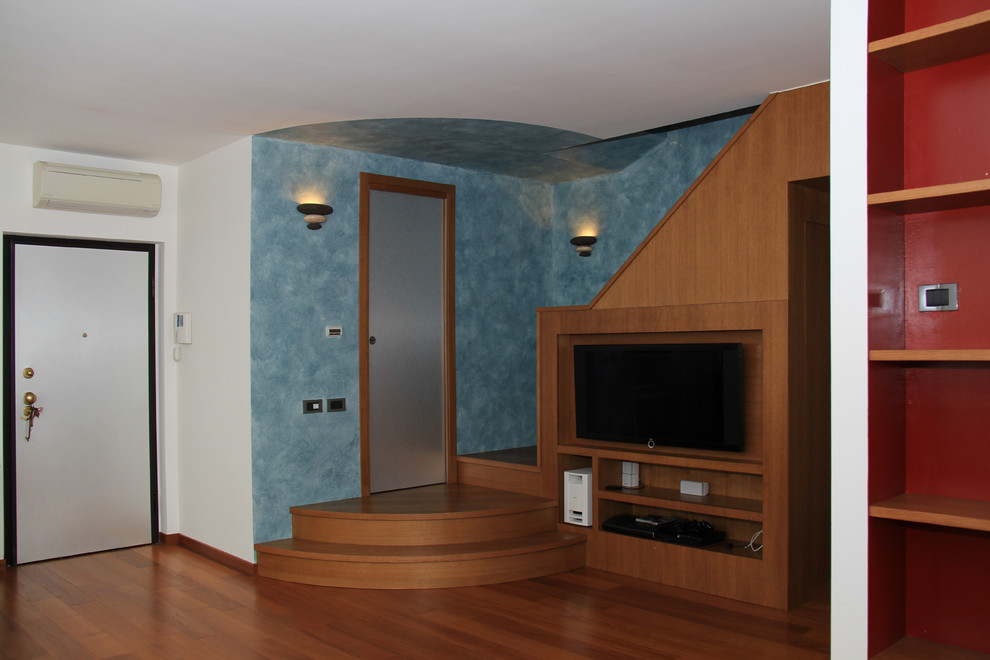 Immagine di un grande soggiorno moderno aperto con pareti multicolore, pavimento in legno massello medio e parete attrezzata