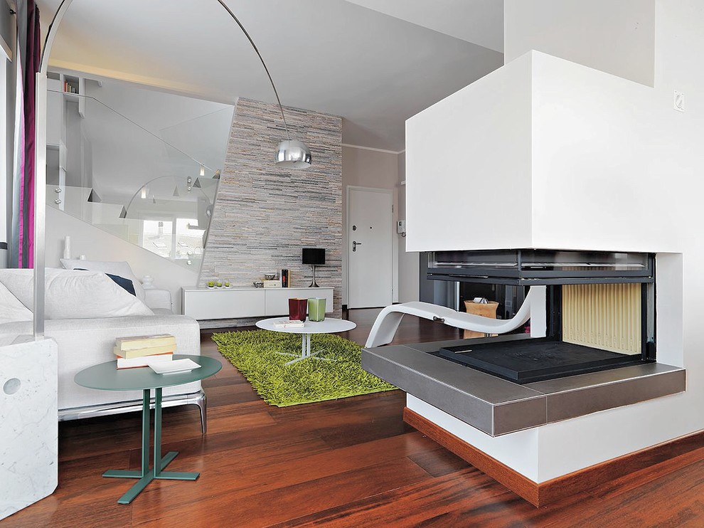 Großes, Offenes Modernes Wohnzimmer mit weißer Wandfarbe, braunem Holzboden, Tunnelkamin und verputzter Kaminumrandung in Turin