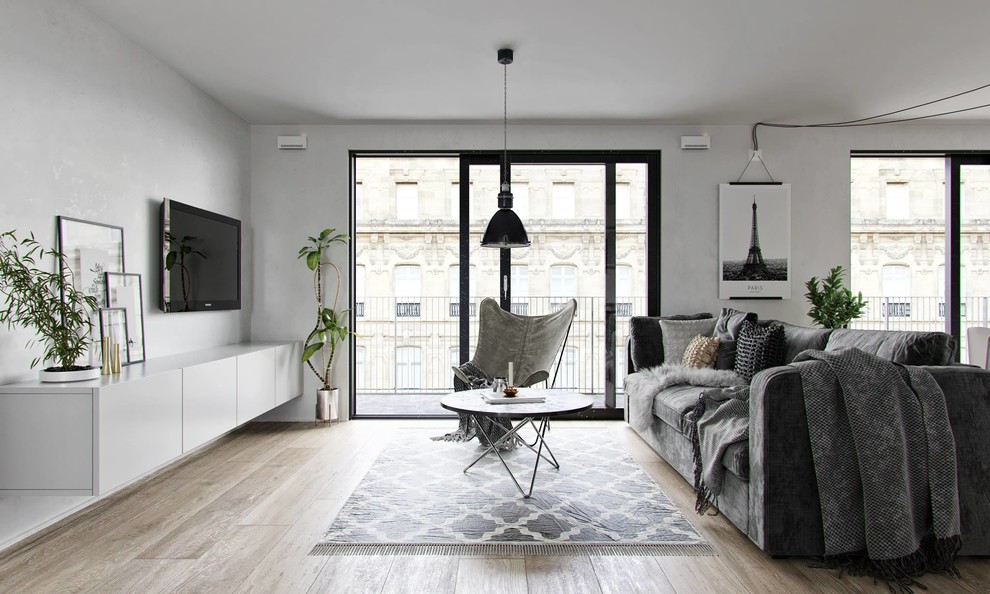 Immagine di un soggiorno scandinavo aperto con sala formale, pareti grigie, pavimento in legno massello medio, TV a parete e pavimento marrone