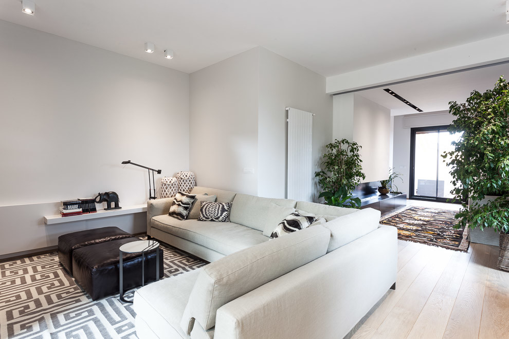 Example of a trendy open concept light wood floor family room design in Bologna with white walls