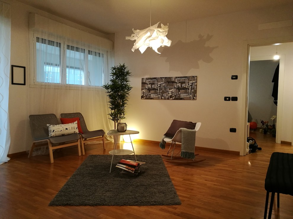 Ejemplo de sala de estar abierta minimalista con paredes blancas, suelo de madera en tonos medios y suelo marrón