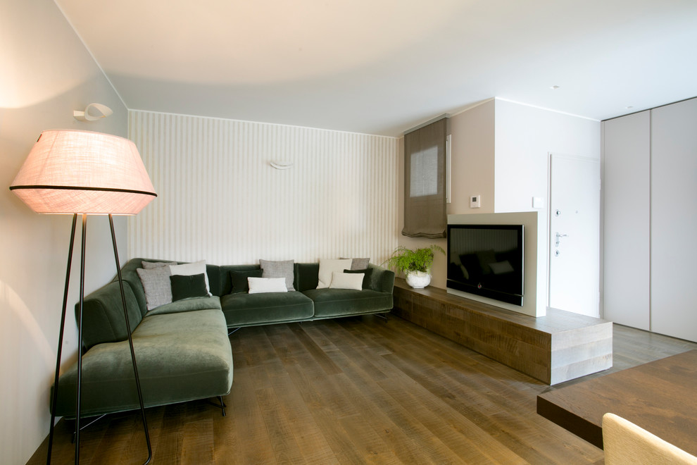 Foto de salón para visitas abierto moderno grande con paredes beige, suelo de madera oscura y pared multimedia