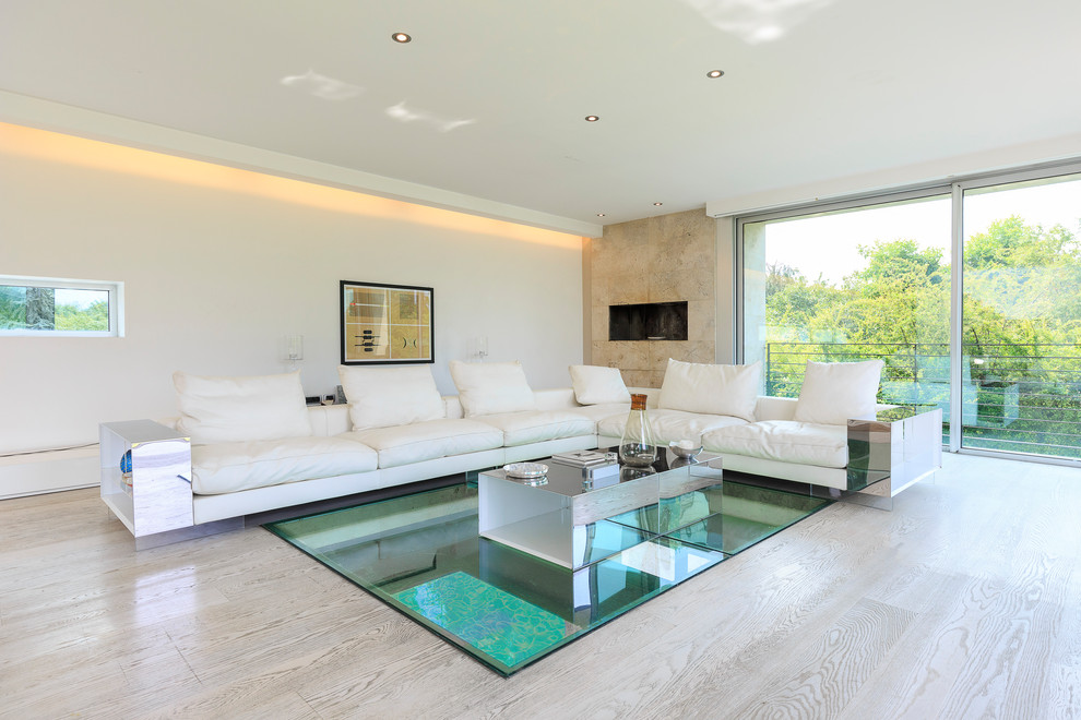 Offenes Modernes Wohnzimmer mit weißer Wandfarbe, Gaskamin, beigem Boden, hellem Holzboden und gefliester Kaminumrandung in Mailand