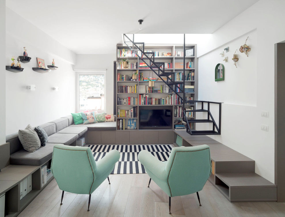 Ispirazione per un soggiorno design con libreria, pareti bianche, parquet chiaro, nessun camino e parete attrezzata