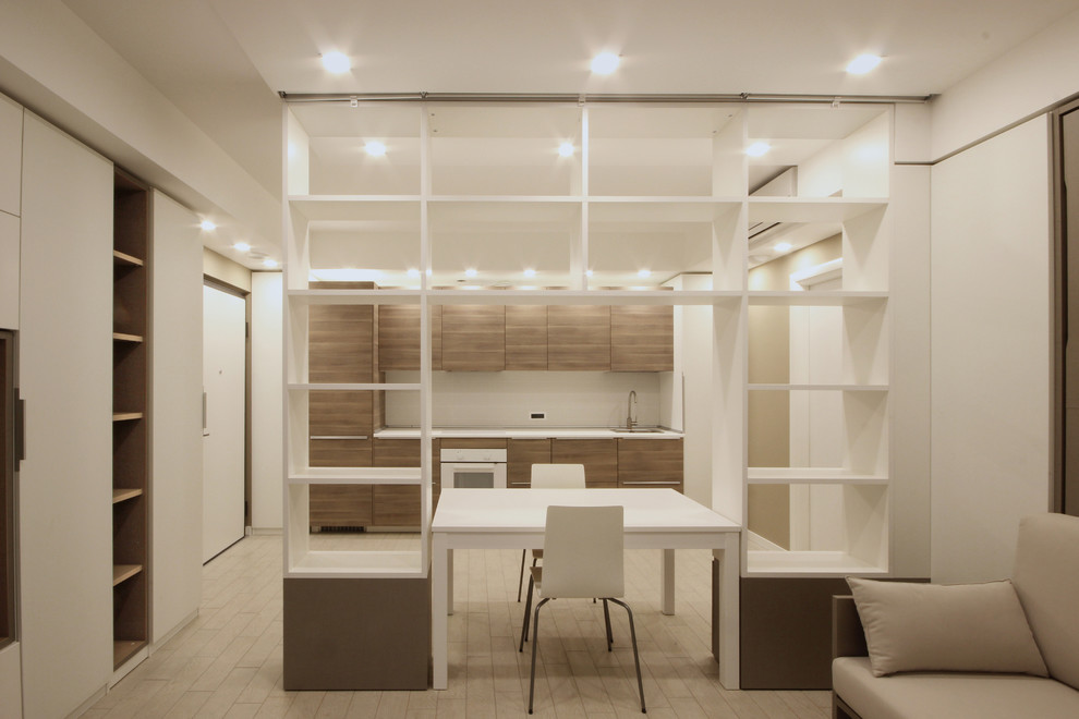 Exempel på ett litet modernt allrum med öppen planlösning, med ett bibliotek, vita väggar, klinkergolv i porslin, en väggmonterad TV och beiget golv