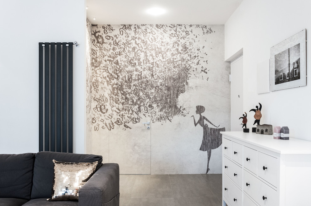 На фото: изолированная гостиная комната среднего размера в современном стиле с белыми стенами, полом из керамогранита, отдельно стоящим телевизором и серым полом без камина с
