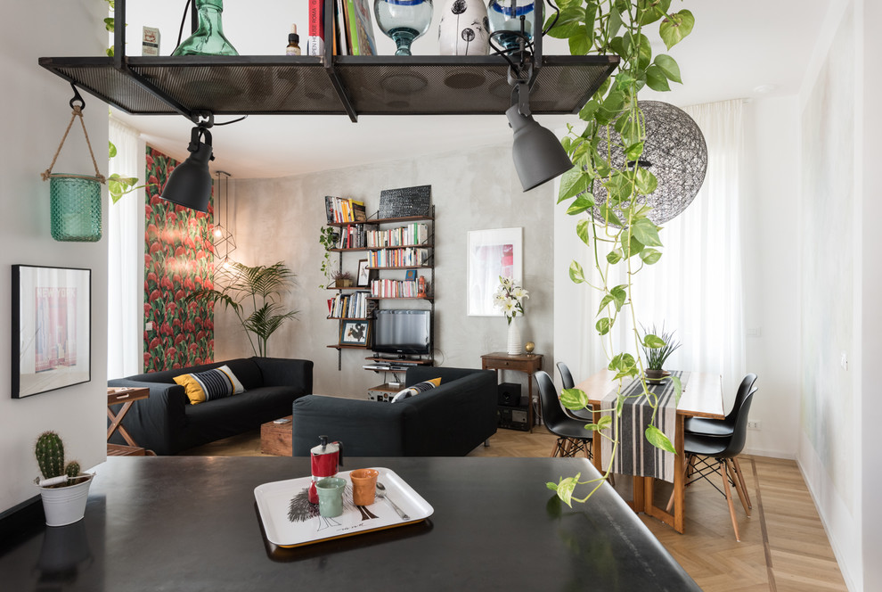 Imagen de sala de estar con biblioteca abierta contemporánea con paredes grises, suelo de madera clara, televisor independiente y suelo marrón