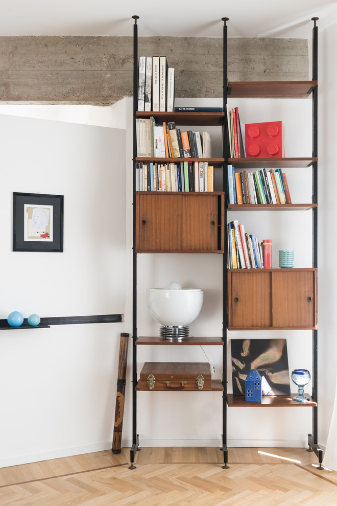 Offene Moderne Bibliothek mit grauer Wandfarbe, hellem Holzboden, freistehendem TV und braunem Boden in Rom
