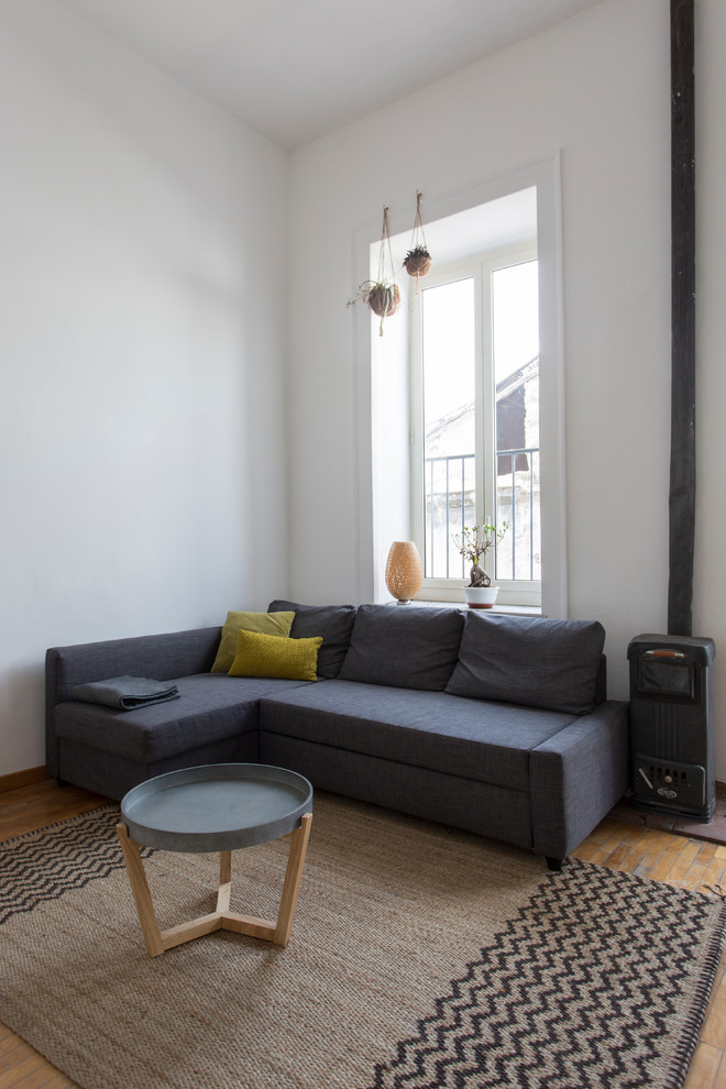 Modelo de sala de estar abierta escandinava grande sin chimenea con paredes blancas, suelo de madera en tonos medios, televisor colgado en la pared y suelo beige