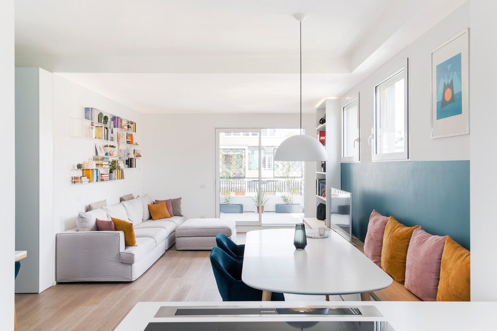 Foto di un soggiorno design di medie dimensioni e aperto con libreria, pareti blu, pavimento in legno massello medio e TV autoportante