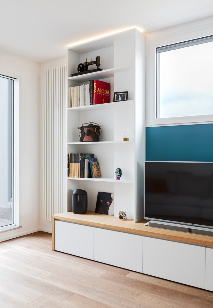 Idee per un soggiorno di medie dimensioni e aperto con libreria, pareti blu, pavimento in legno massello medio e TV autoportante