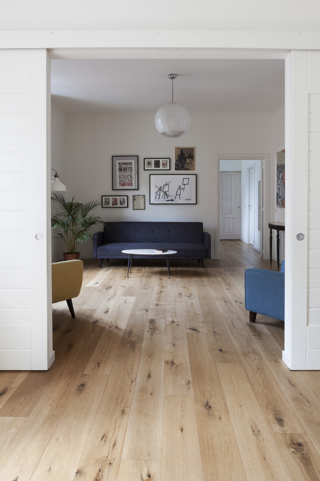 Cette photo montre un salon scandinave de taille moyenne et ouvert avec un mur blanc, parquet clair, aucun téléviseur et un sol marron.