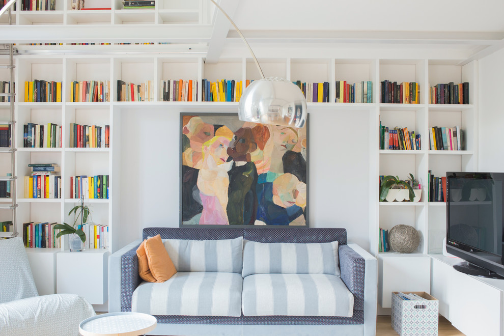 Стильный дизайн: гостиная комната в скандинавском стиле с с книжными шкафами и полками, белыми стенами и отдельно стоящим телевизором - последний тренд