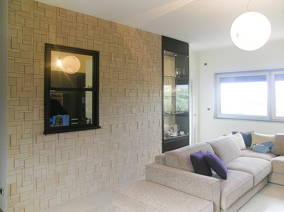 Imagen de sala de estar abierta moderna de tamaño medio con paredes beige, suelo de baldosas de porcelana, pared multimedia y suelo beige