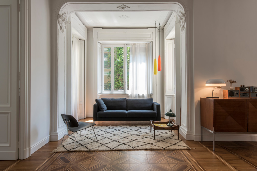 Mittelgroßes, Fernseherloses Modernes Musikzimmer im Loft-Stil, ohne Kamin mit weißer Wandfarbe, braunem Holzboden und braunem Boden in Mailand