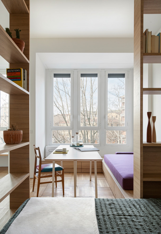 Idéer för ett litet modernt allrum med öppen planlösning, med ett bibliotek, vita väggar och mellanmörkt trägolv