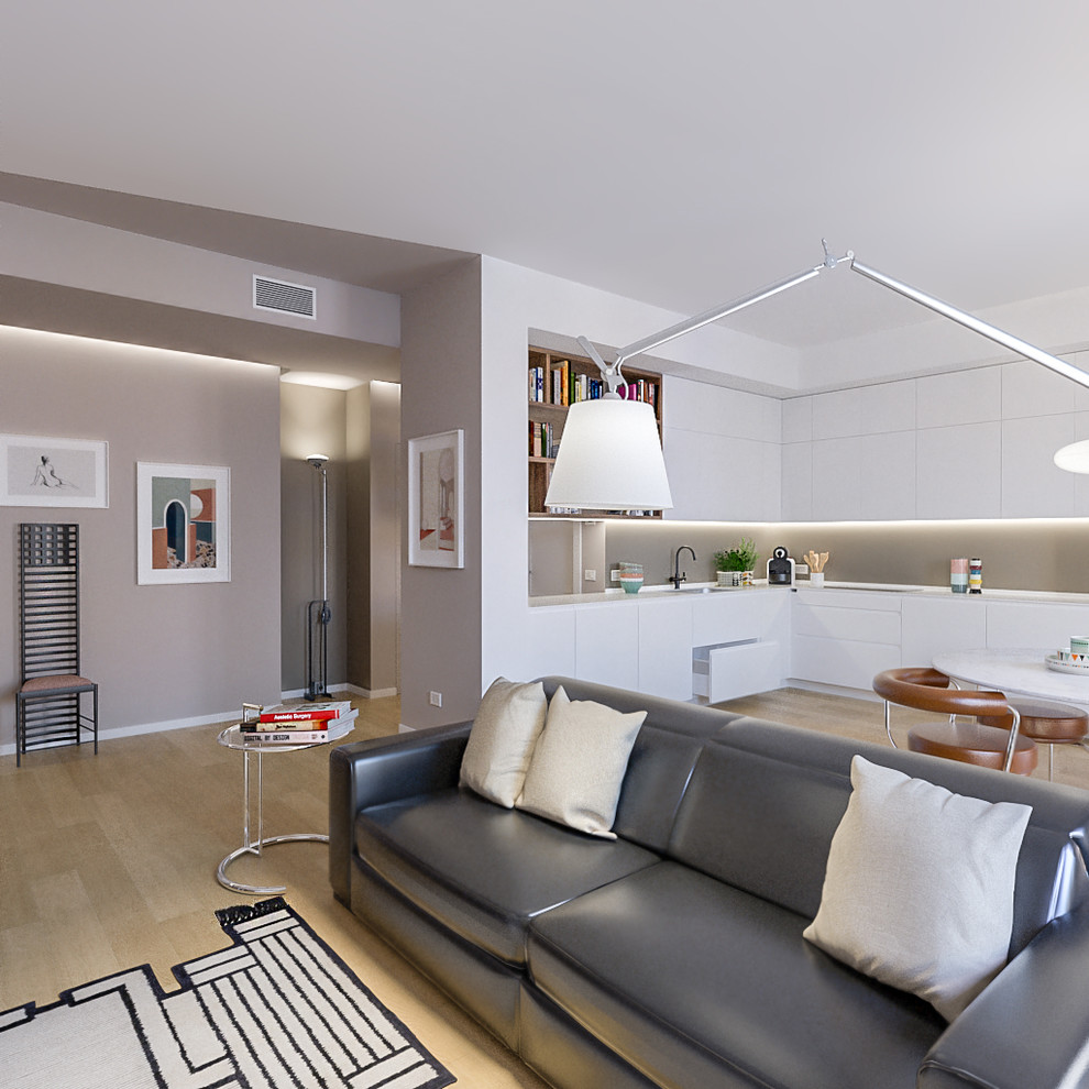 Imagen de salón abierto actual de tamaño medio con paredes beige, suelo de madera clara y televisor colgado en la pared