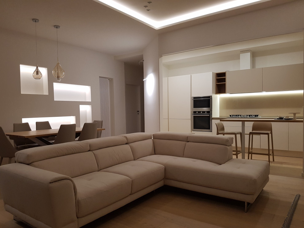 Idée de décoration pour une salle de séjour minimaliste de taille moyenne et ouverte avec un mur blanc et parquet clair.