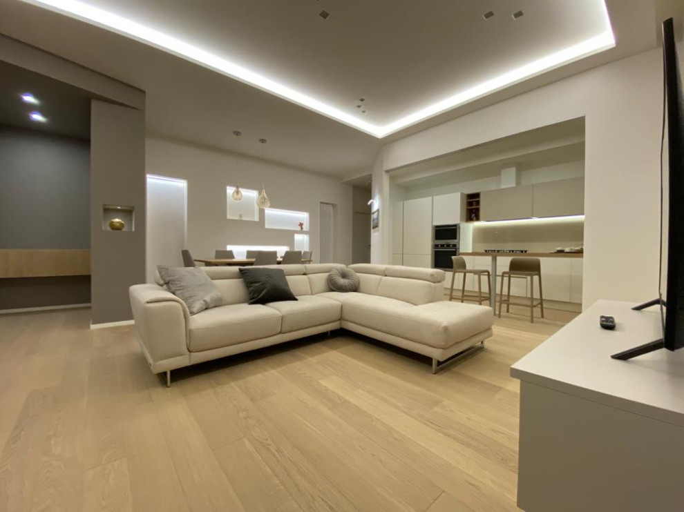 Ispirazione per un soggiorno moderno di medie dimensioni e aperto con pareti bianche e parquet chiaro