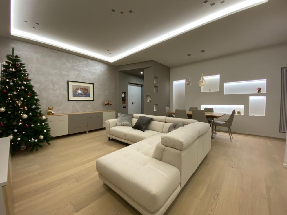 Immagine di un soggiorno moderno di medie dimensioni e aperto con pareti bianche e parquet chiaro