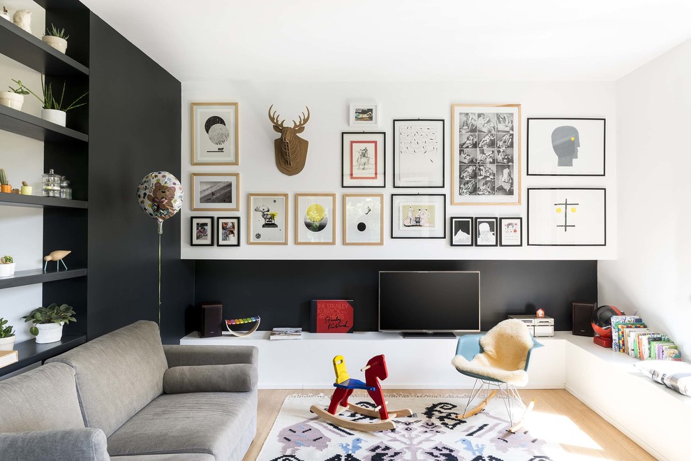Diseño de salón cerrado nórdico con paredes negras, suelo de madera clara y televisor independiente