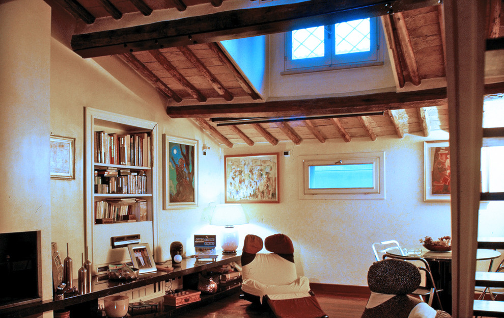 Immagine di un grande soggiorno moderno chiuso con pareti beige, pavimento in terracotta, camino classico, cornice del camino in intonaco, TV nascosta e pavimento marrone