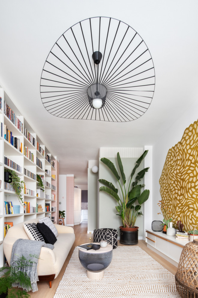 Immagine di un grande soggiorno scandinavo chiuso con libreria, pareti multicolore, parquet chiaro e pavimento beige