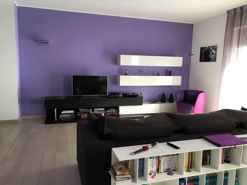 Design ideas for a large contemporary enclosed living room in Milan with purple walls, light hardwood flooring, a wall mounted tv and beige floors.